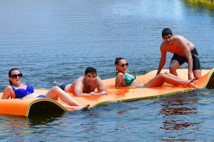 a group of people riding on the back of a boat in the water