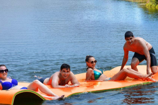 a group of people riding on the back of a boat in the water